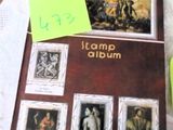 une photo d'un livre orné de timbres, à côté d'une tasse de café