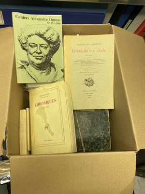 de nombreux livres dans une boîte en carton posée sur une table