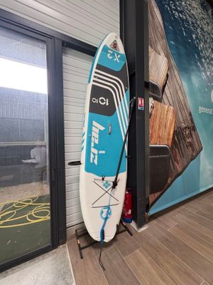 une planche de surf appuyée contre un mur dans un immeuble