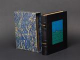 an old book with a blue cover sitting on top of a table