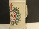 une tasse blanche avec un bord rouge et un blason dessus