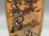 a gold vase with a picture of a dragon on it