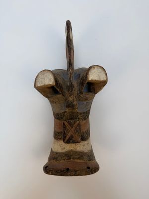 une vieille sculpture en bois représentant une tête de taureau, accrochée au mur