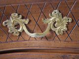a close up of a brass handle on a wooden cabinet