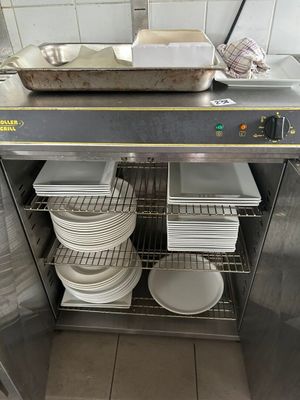 de nombreuses assiettes et casseroles empilées sur une étagère dans la cuisine