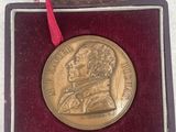 a gold medal in a case with a red ribbon