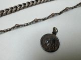 a silver chain with a coin attached to it