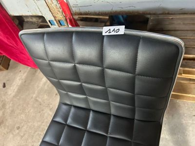un fauteuil en cuir noir sur lequel est accrochée une étiquette de prix