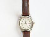 wrist watch with brown leather strap on white surface