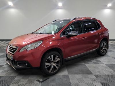 une voiture rouge est garée dans une pièce au sol en damier