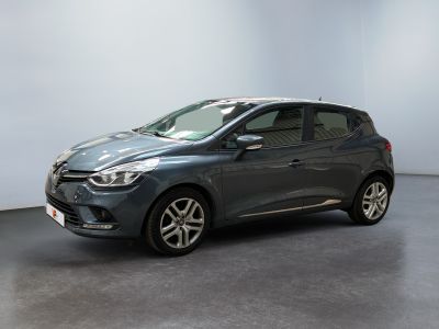 a grey car is parked in a room with a white wall