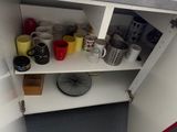 many cups and mugs sitting on a shelf in a cabinet