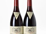 two bottles of wine sitting next to each other on a white surface