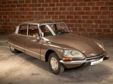 a brown car that is parked in front of a brick wall
