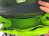 a person holding a green purse in their hand
