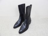 a pair of black leather boots on a white surface