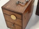 a small wooden box that has a handle on it