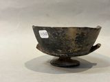 a small metal bowl on a stand with a tag on it