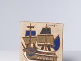 une image représentant une petite plaque en bois sur laquelle figure un bateau