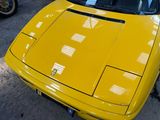 a yellow sports car parked in a garage next to other cars