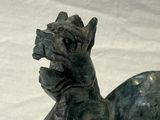 a statue of a dragon sitting on a marble base