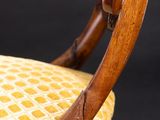a close up of a wooden chair with a wicker seat