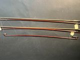four wooden knitting needles on a table with a black background