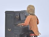 a small figurine of a man playing a piano