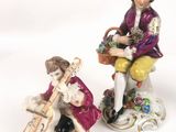 two figurines of a man and a woman sitting on a bench