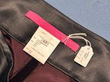 a close up of a black pants with a pink label on it