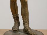 bronze statue of a man holding a tennis racquet on top of a wooden table