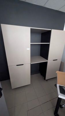une photo d'une pièce avec un bureau d'ordinateur et des armoires