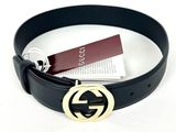 une ceinture en cuir noir avec une boucle dorée et une étiquette