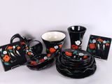de nombreuses pièces de vaisselle noire et rouge disposées sur une table