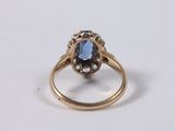 a close up of a gold ring with a blue stone on it