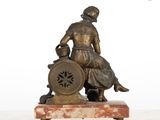 bronze statue of a woman sitting on a chair with a shield and shield