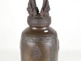 an old bronze vase with a bird on top of it