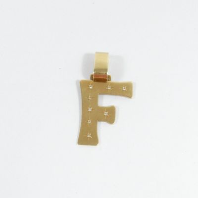 un pendentif en or sur lequel est gravée la lettre « f »
