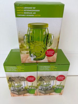 deux boîtes contenant des vases en verre vert, empilées l'une sur l'autre
