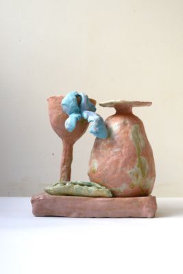 un petit vase surmonté d'un oiseau bleu