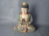statue d'un Bouddha assis en position de méditation sur un fond gris