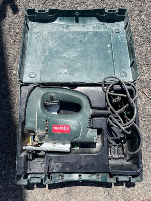 une boîte verte contenant un cordon d'alimentation et un outil