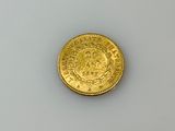 an old gold coin on a white surface with a white background