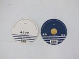 two disc labels on a white surface one has a gold coin and the other has a black and white label