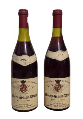 two bottles of wine sitting next to each other on a white surface