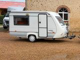 an image of a camper trailer parked in front of a building