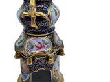a blue and gold vase with a bird on it