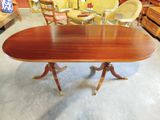 a large oval table with four legs and a wooden top