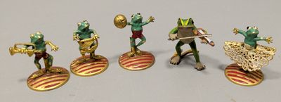 five figurines of frogs that are standing on top of each other