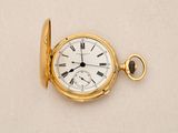 a gold pocket watch with roman numerals on it